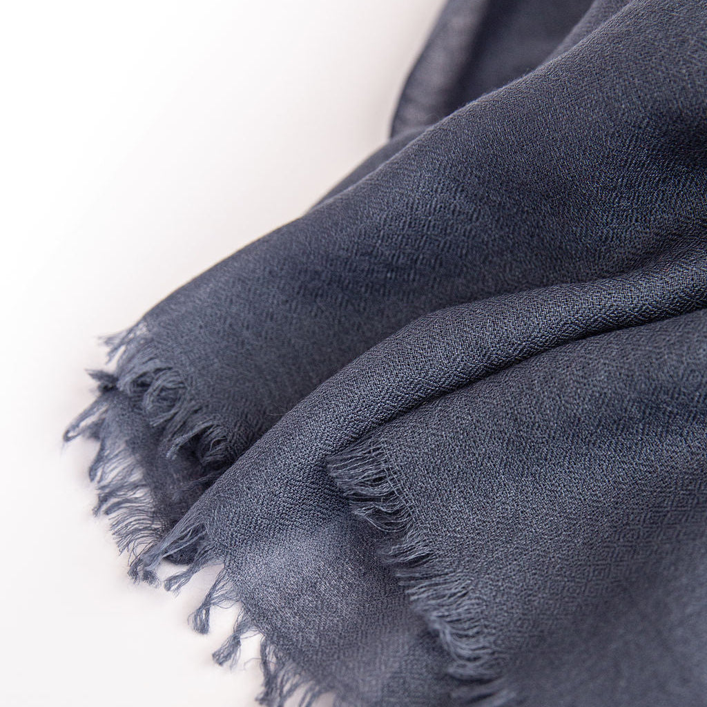 Gray  scarf with frayed edges on a white background